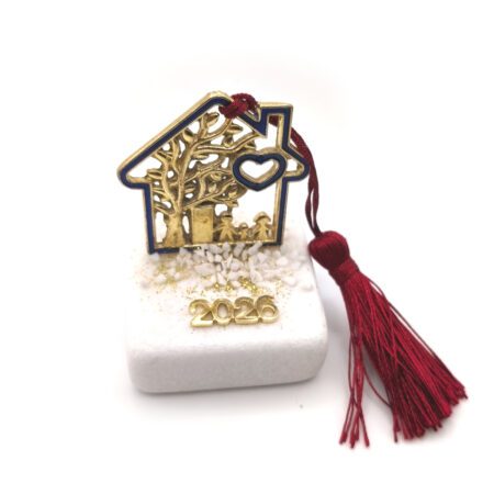 Επιτραπέζιο γούρι 2026 με μεταλλικό σπίτι και οικογένεια, σε μαρμάρινη βάση με κόκκινη φούντα.